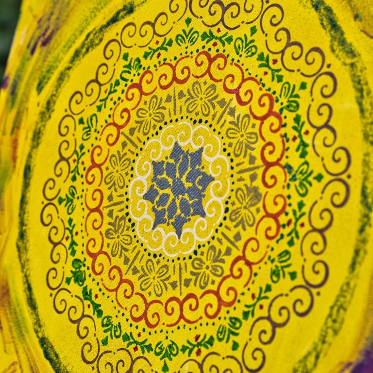 Des cartes de tarot colorées, des cristaux et de la sauge disposés sur une table rustique évoquent des thèmes mystiques et spirituels à Dubaï.